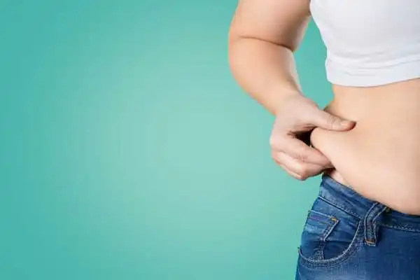 Image of woman pinching her love handles to show weight gain Sunninghill
